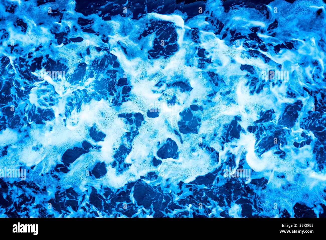 Aerial Ocean water surface with foam and waves behind of fast moving ...