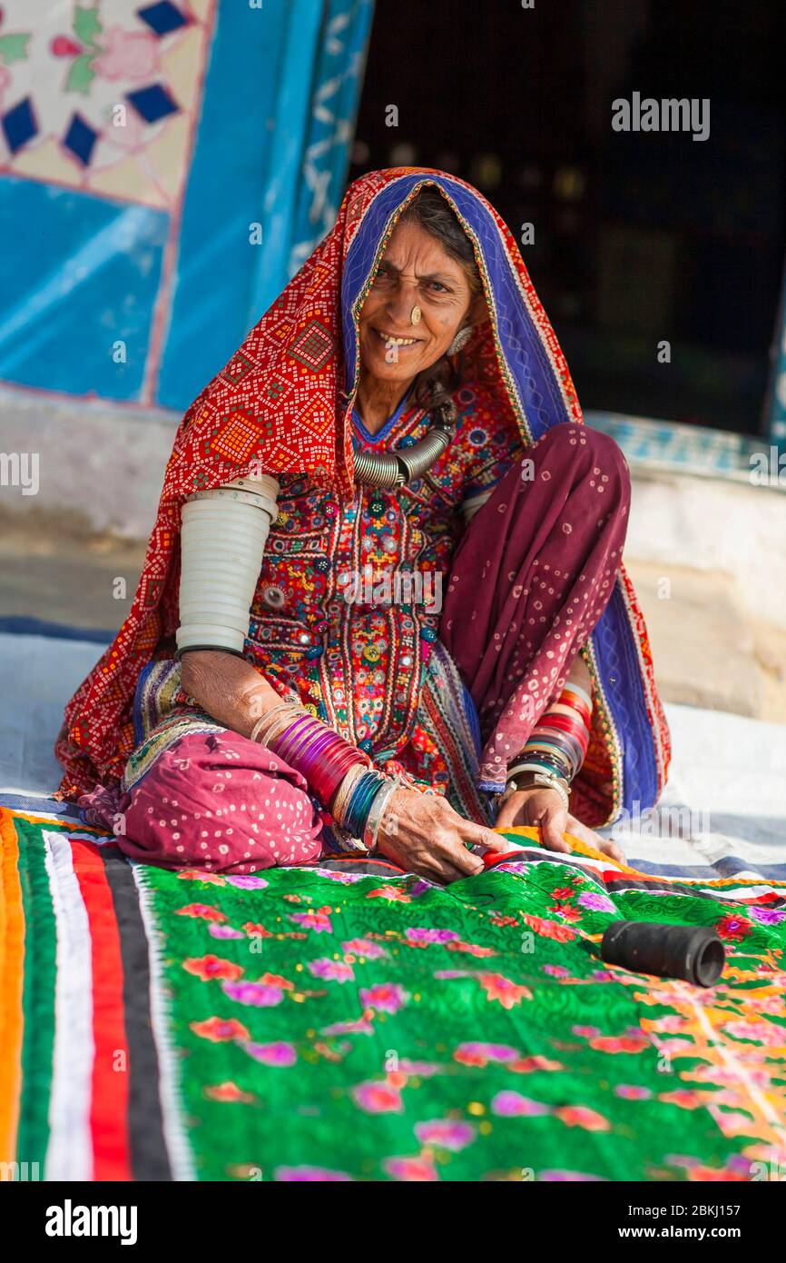 India, Gujarat State, Kutch region, Adipur village, nearby Bhuj city, Meghwal tribal woman wearing traditional embroidered clothes in front of hut decorated with colorful patterns Stock Photo