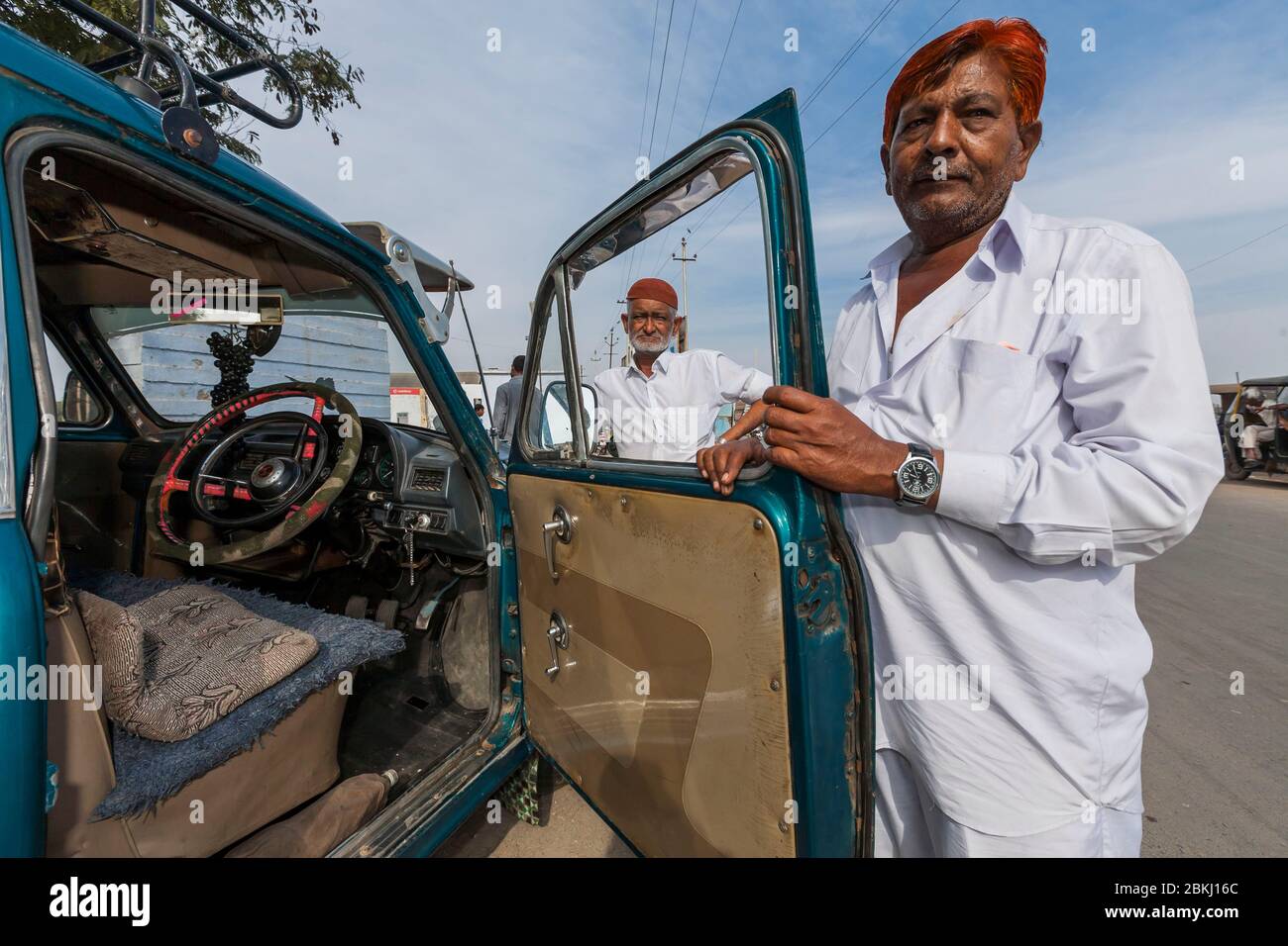 India, Gujarat State, Mandvi, taxi driver opening the door of his Ambassador brand car, detail of driver's seat, first automobile manufactured in India, by Hindustan Motors, from 1958 to 2014 Stock Photo