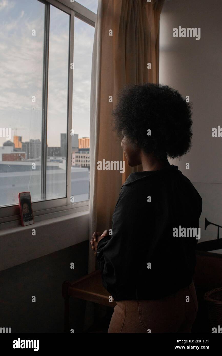 Young African girl standing by the window Stock Photo
