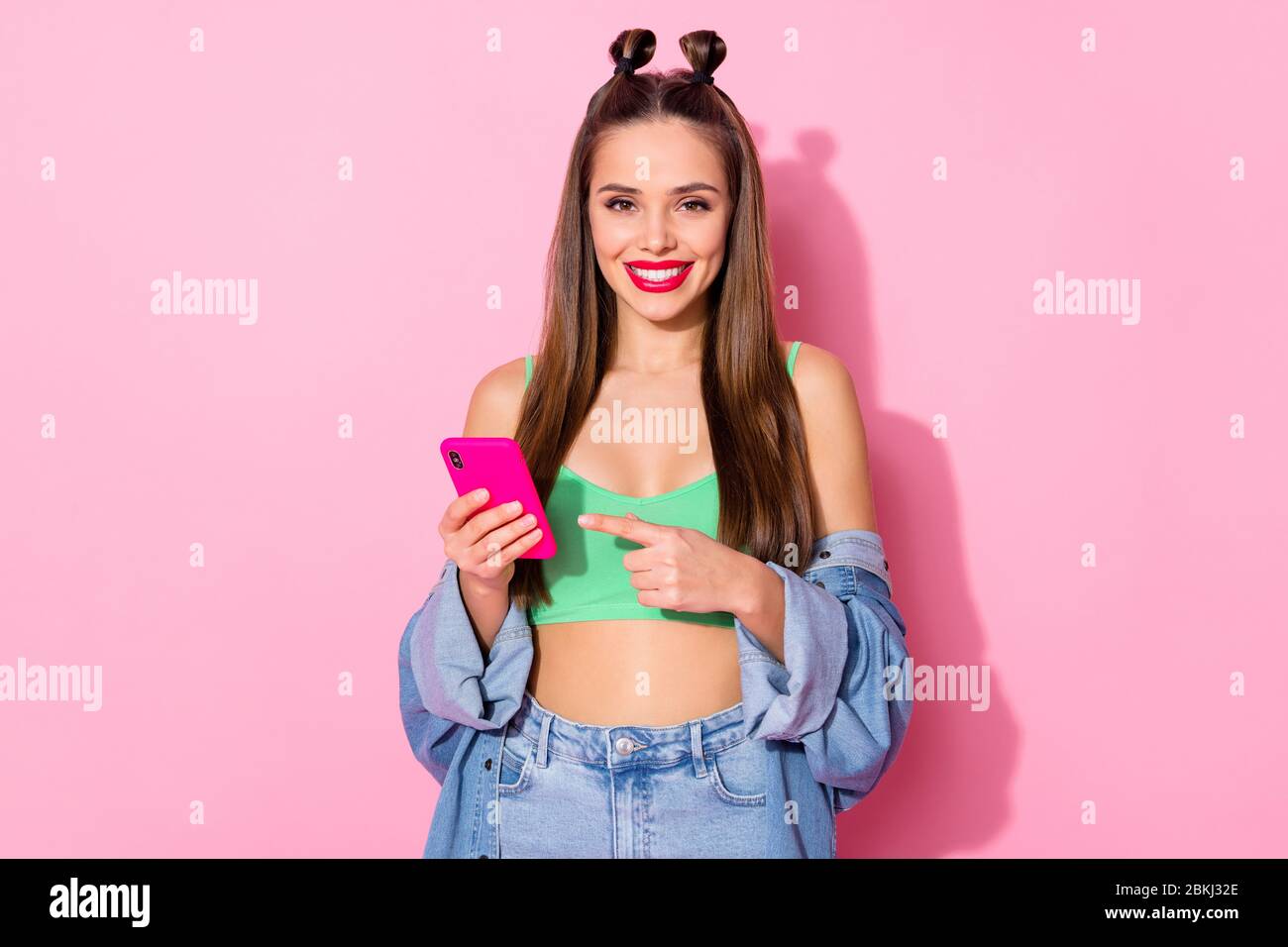 Positive girl blogger promoter teenager use smart phone indicate social  media ads promotion point index finger recommend select wear denim jeans  green Stock Photo - Alamy
