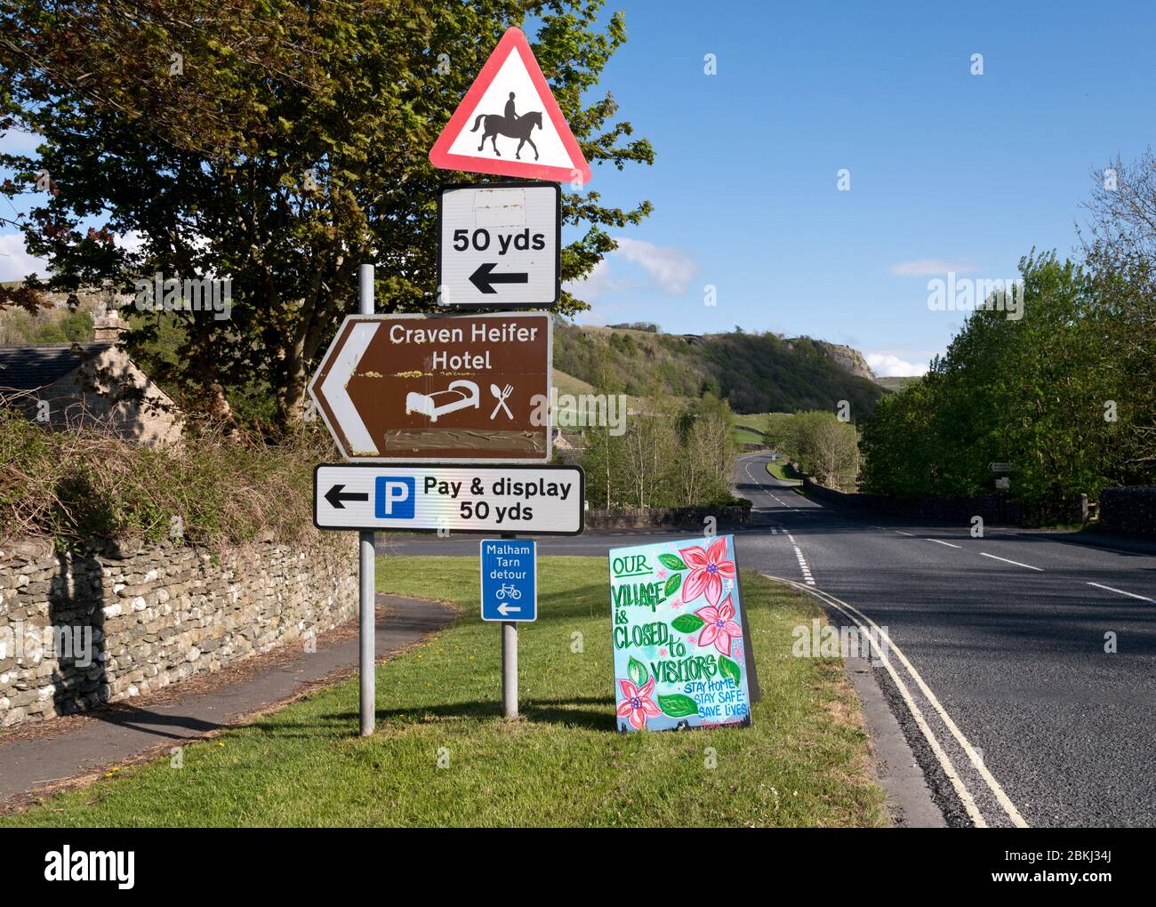 Stainforth, North Yorkshire, UK. 4th May 2020. Covid-19 lockdown in the countryside. Sign saying 'Our Village is closed to visitors. Stay at Home, Stay Safe, Save Lives'. Stainforth, Yorkshire Dales National Park, UK. Credit: John Bentley/Alamy Live News Stock Photo