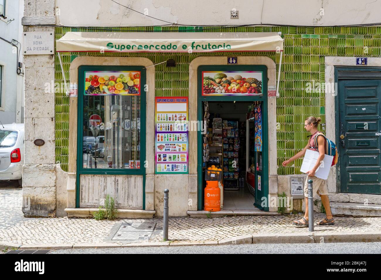 Portugal, Lisbon, Bairro Alto district, man walking past a neighborhood