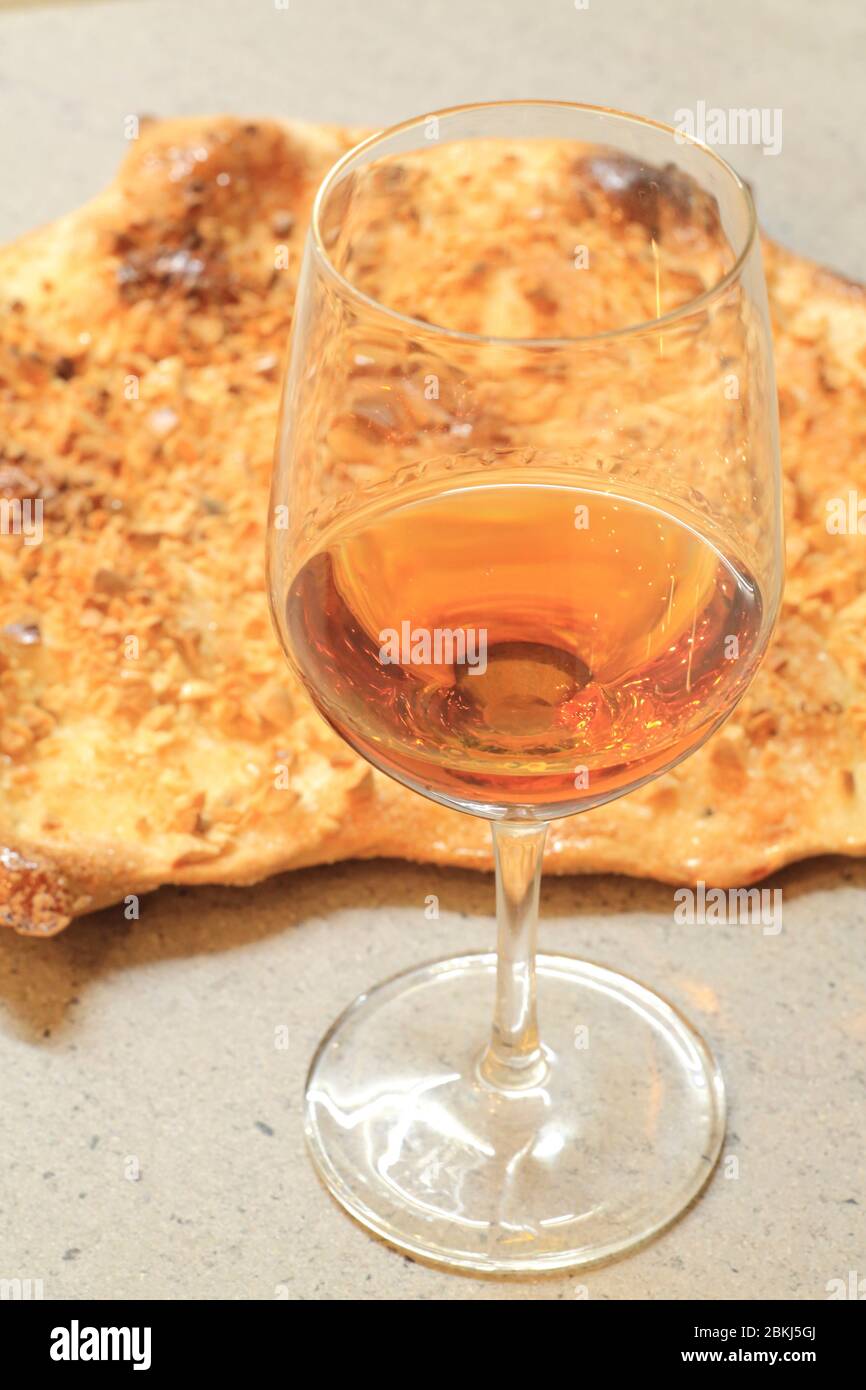Spain, Catalonia, Girona, natural sweet wine from Empordà and Catalan coca (Coca de vidre) sweetened with almond pieces Stock Photo