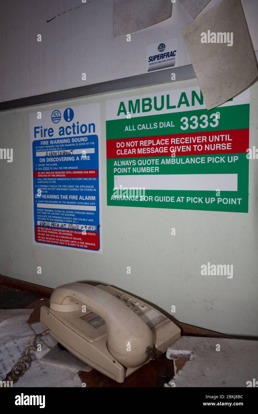 Emergency signage next to a phone ambulance fire action telephone 'phone Stock Photo