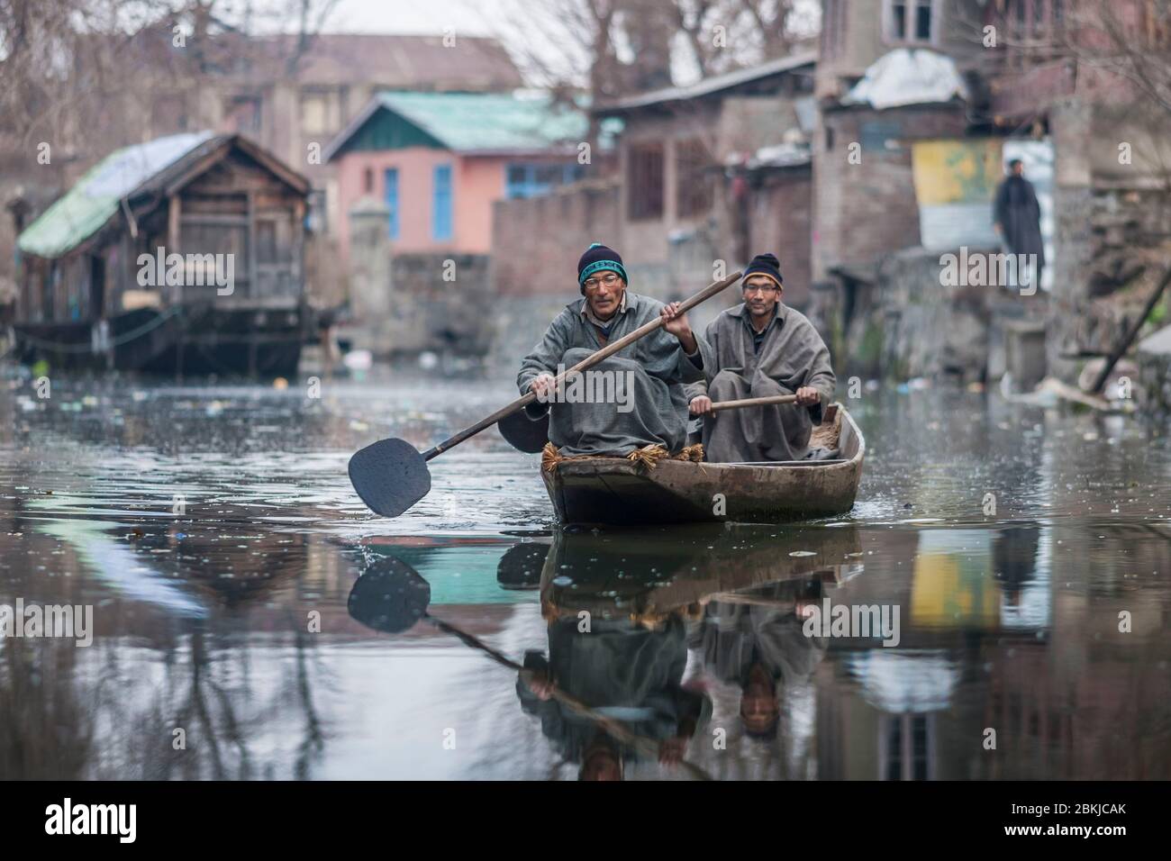 India, Jammu and Kashmir, Srinagar, Dal lake, canals in the city, men on a shikara, Kashmiri pirogue, and wearing a pheran, traditional woollen poncho Stock Photo