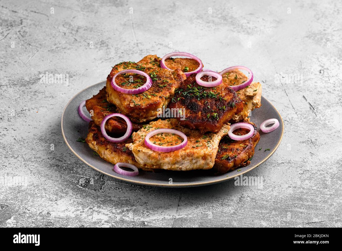 Pork fillet mignon roasted on cast iron pan, served with red onion and dill Stock Photo
