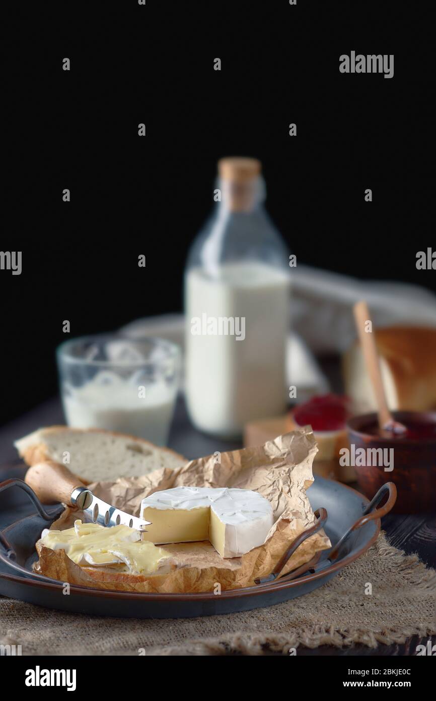 Rustic country breakfast with brie cheese, milk, baguette and cranberry
