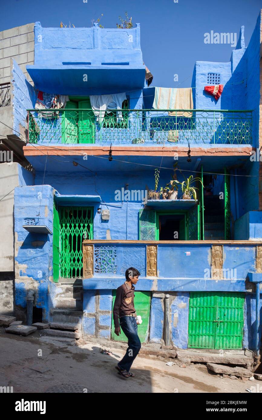India, Rajasthan, Jodhpur, young man walking by the facade of a blue house Stock Photo