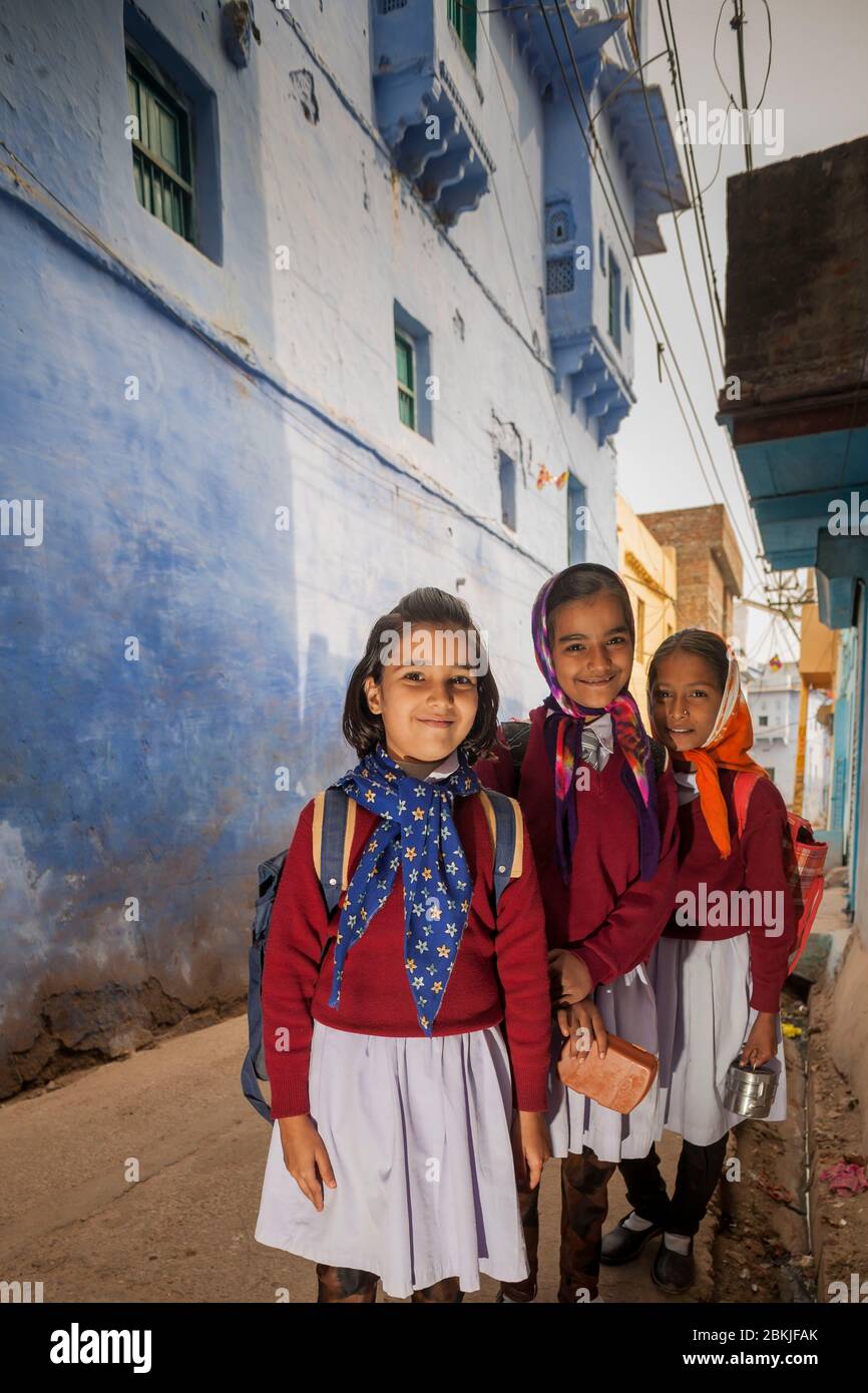 India, Rajasthan, Bundi, group of young schoolgirls wearing uniforms in front of blue house Stock Photo