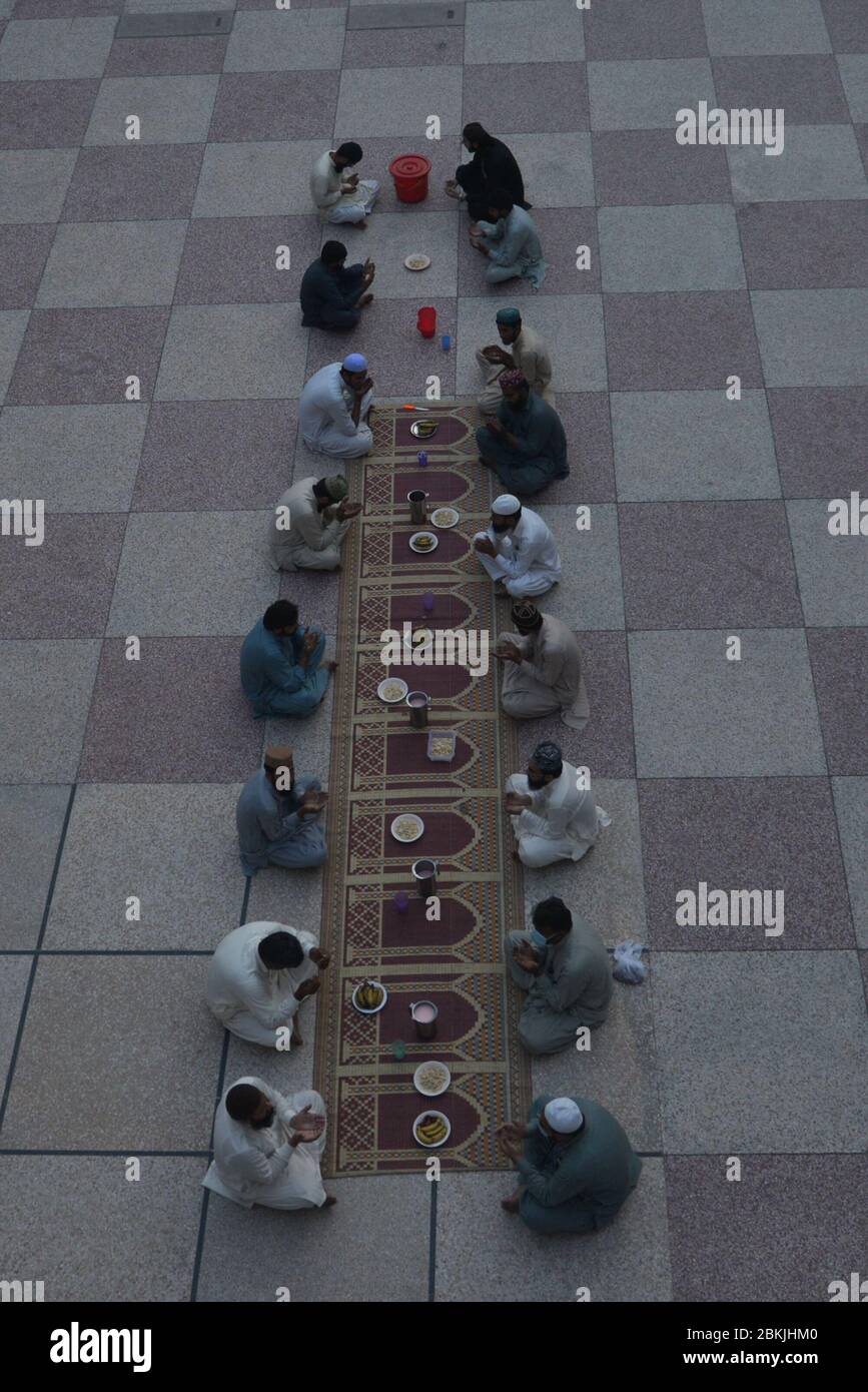 Lahore, Pakistan. 04th May, 2020. Pakistani members of Jamia Naeemia administration offering dua during Iftar as they sit in social distance during Ramazan-ul-Mubarak in provincial capital city Lahore. Millions of Muslims have started Ramadan, the holiest month on the Islamic calendar, under the coronavirus lockdown or strict social restrictions from government of Pakistan. (Photo by Rana Sajid Hussain/Pacific Press) Credit: Pacific Press Agency/Alamy Live News Stock Photo