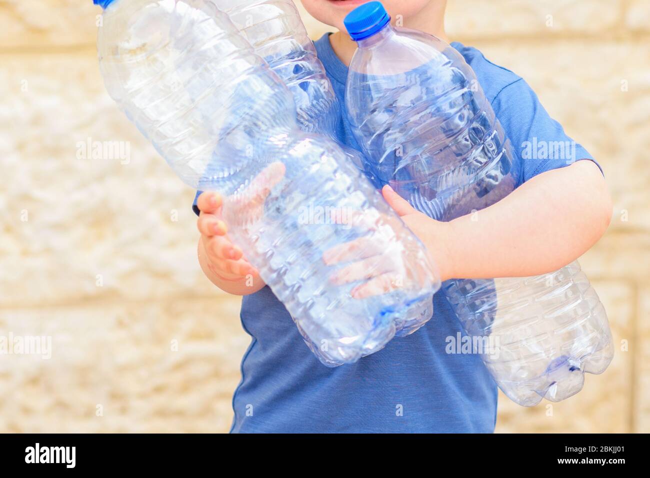 Little child recycling plastic water bottles. Kid taking out the segregated garbage. Concept plastic free, zero waste. World Environment Day. Stock Photo
