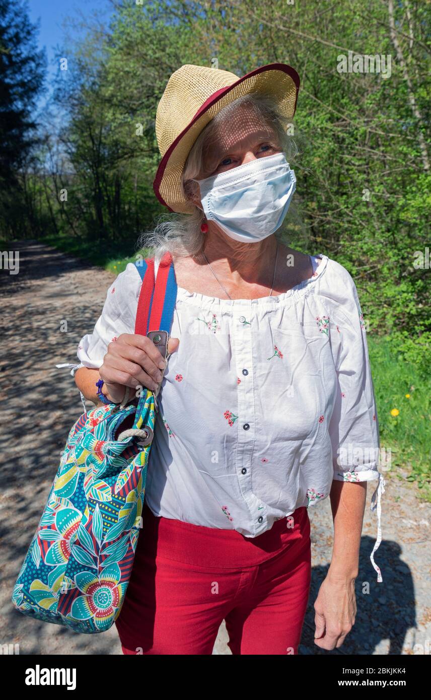 Europe, Luxembourg, Insenborn, Attractive older woman wearing a face mask during the Covid-19 Pandemic Stock Photo