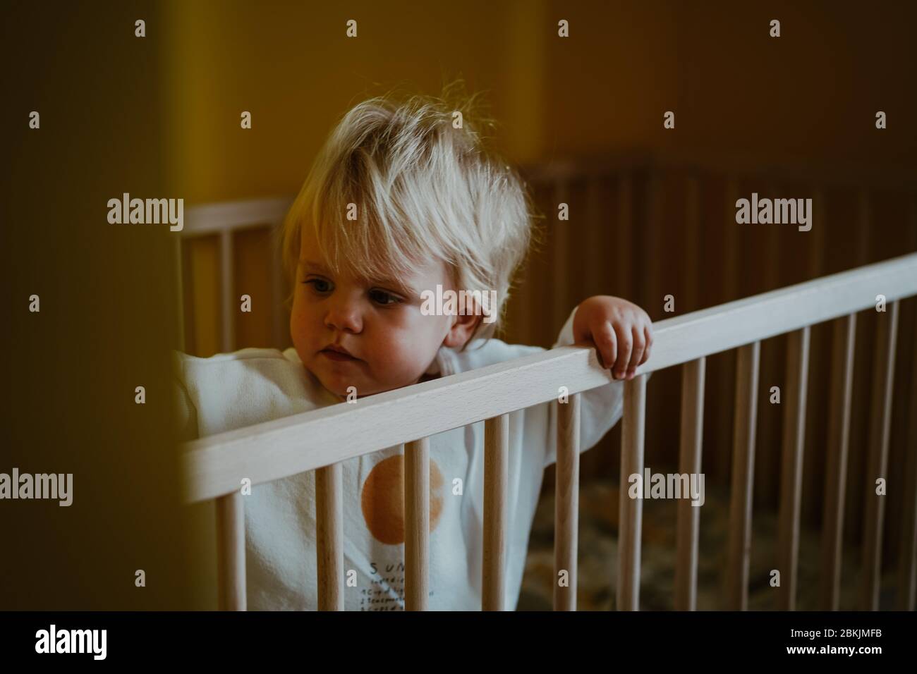 Little boy playing in his cot Stock Photo