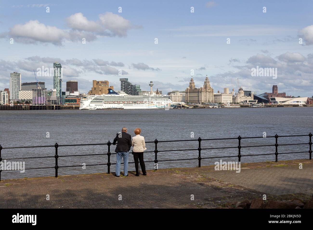Elderly couple view Norwegian Spirit cruise ship on River Mersey, Liverpool from Seacombe ferry terminal. Stock Photo