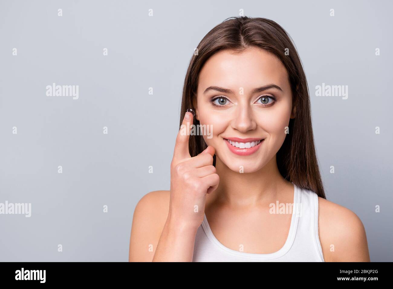Portrait of positive cheerful girl care eye hold transparent contact