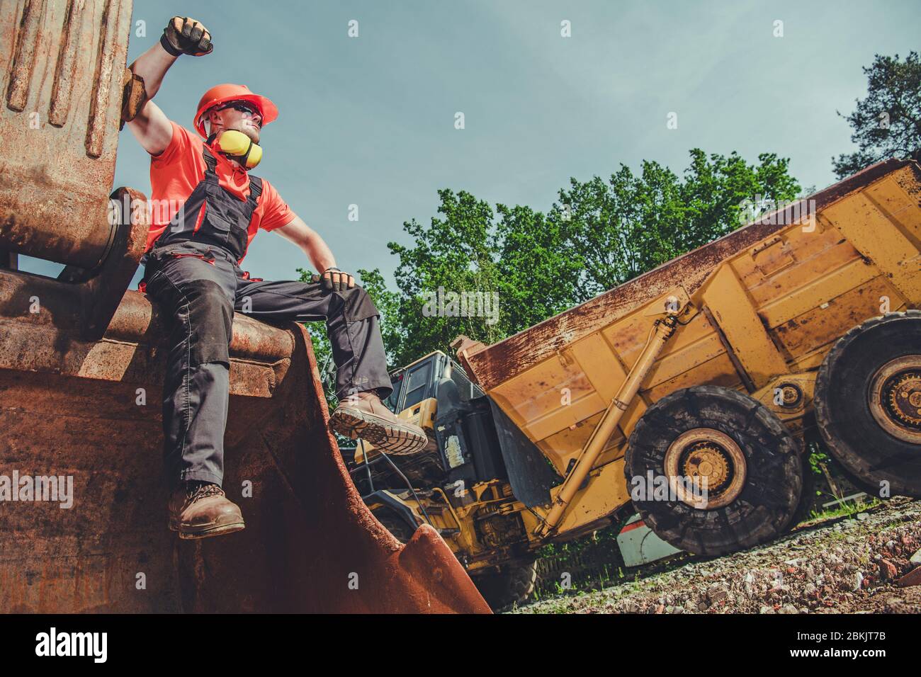 Backhoe Operator Taking Break And Resting On Top Of Heavy Duty