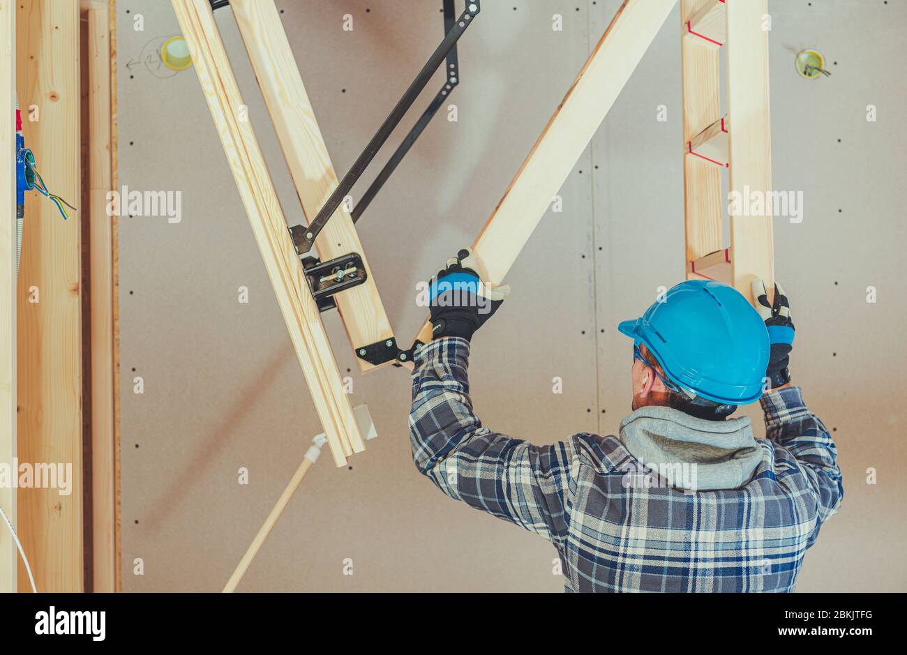 Caucasian Handyman Assembles Attic Access Wooden Ladder Stock Photo - Alamy