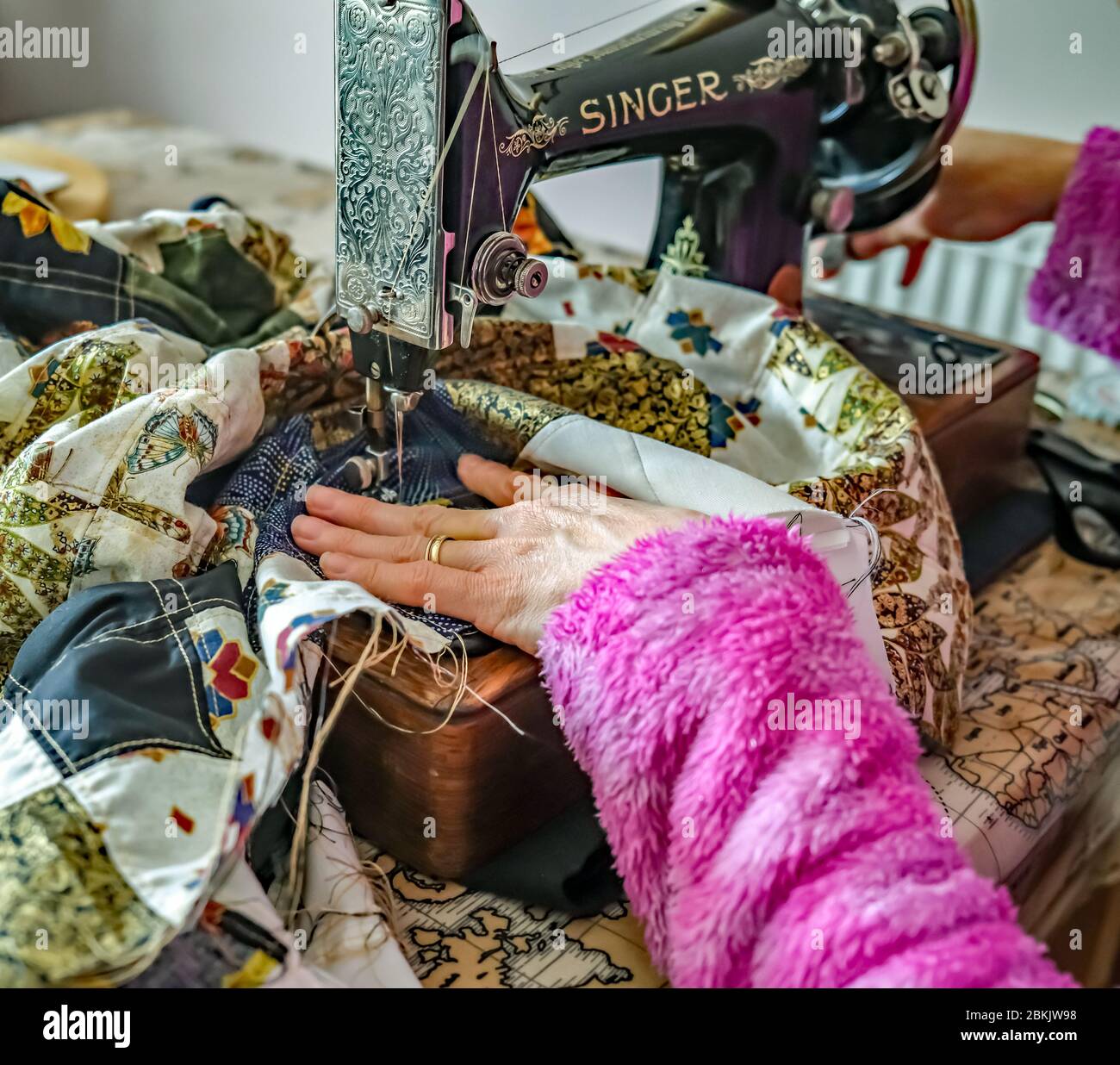 1 Unidentifiable seamstress sewing together a patchwork quilt with a traditional and old