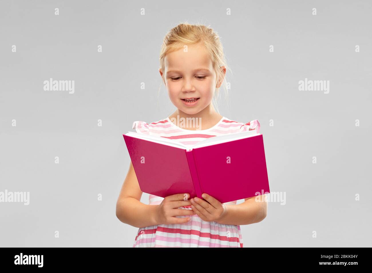 smiling little girl reading book Stock Photo - Alamy