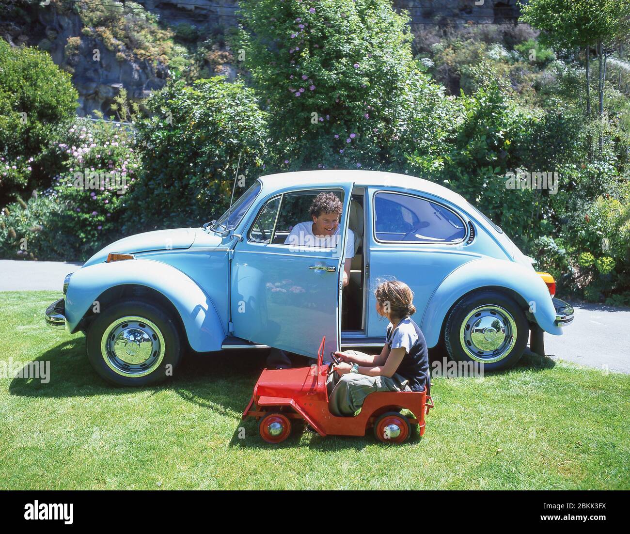 Father and daughter in adult and child vehicles, Sumner, Christchurch, Canterbury Region, New Zealand Stock Photo
