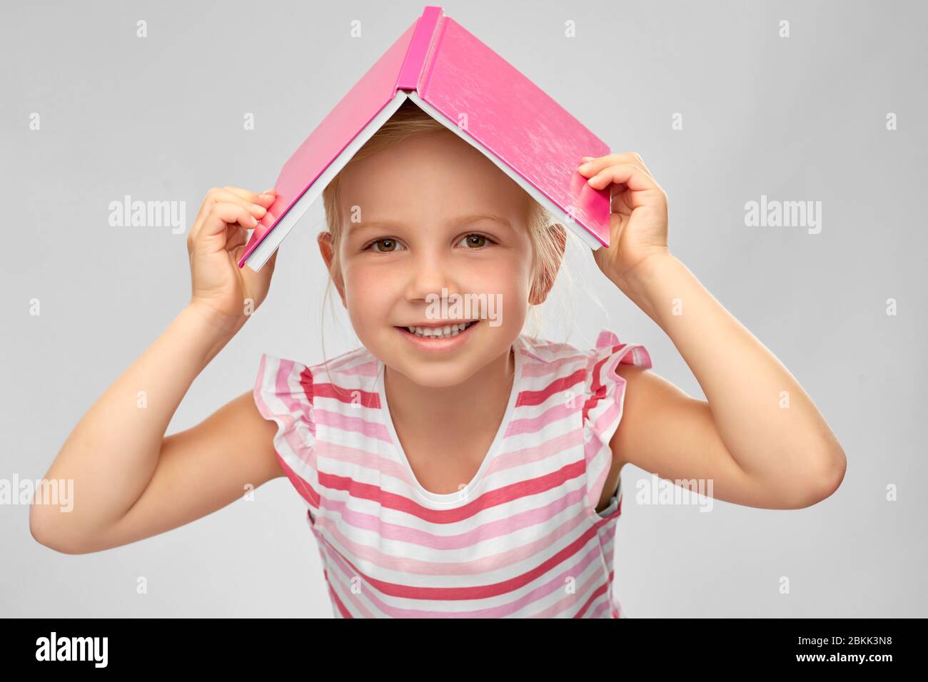 little girl with roof of book on top of her head Stock Photo - Alamy