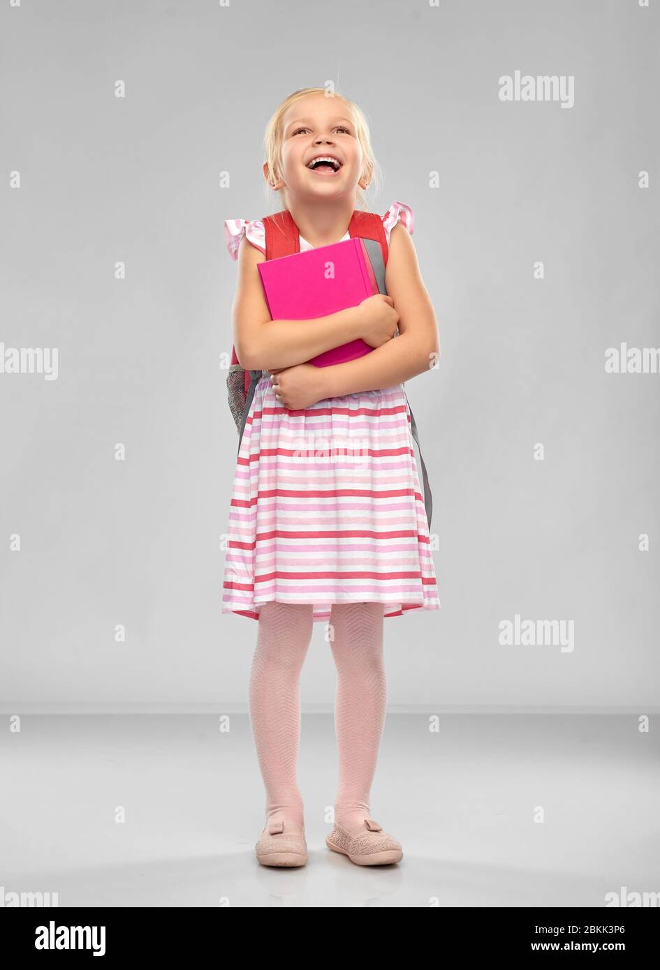 happy little student girl with school bag and book Stock Photo - Alamy