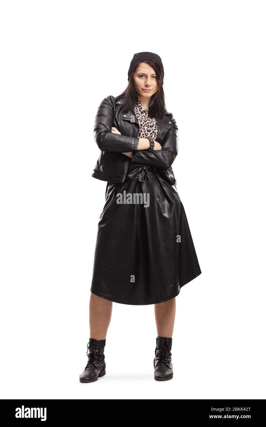 Full length portrait of a young woman in black leather jacket and skirt posing with crossed arms isolated on white background Stock Photo