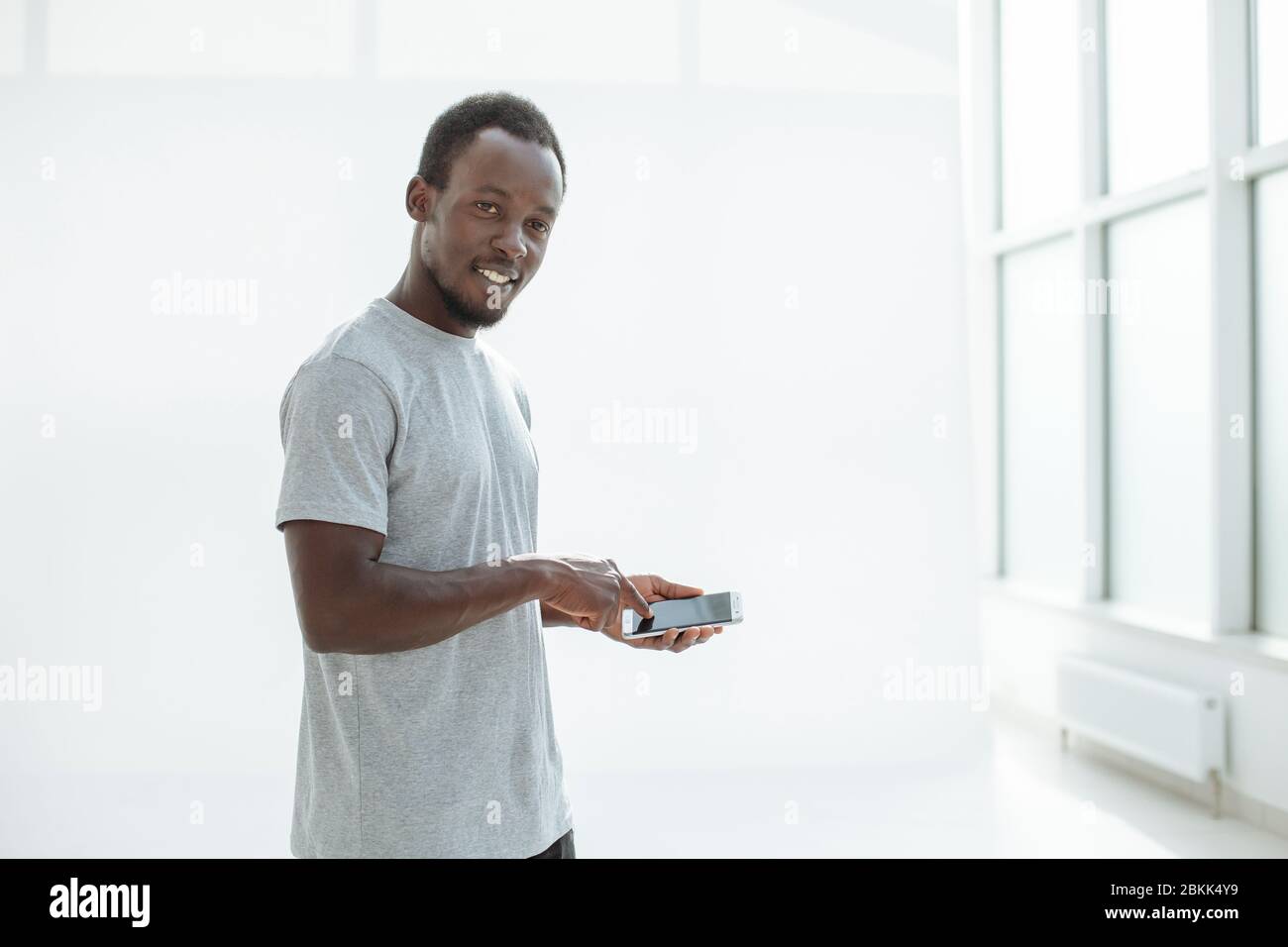 side view. stylish young man using his smartphone. Stock Photo