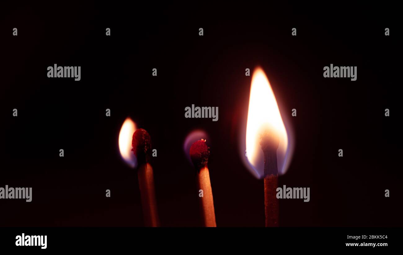 Three match sticks burning isolated on a black background Stock Photo