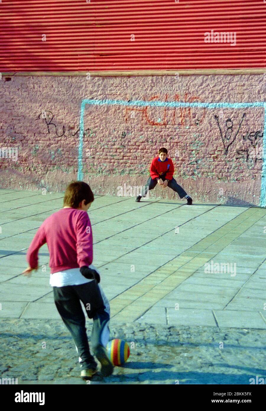 Kids playing soccer in the street hires stock photography and images