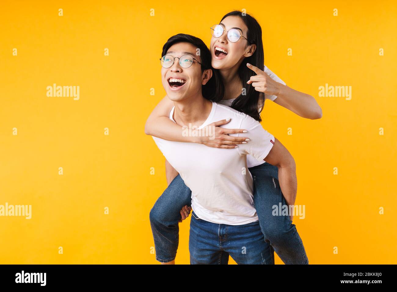 Young couple enjoying piggyback ride isolated on gray background Stock  Photo - Alamy