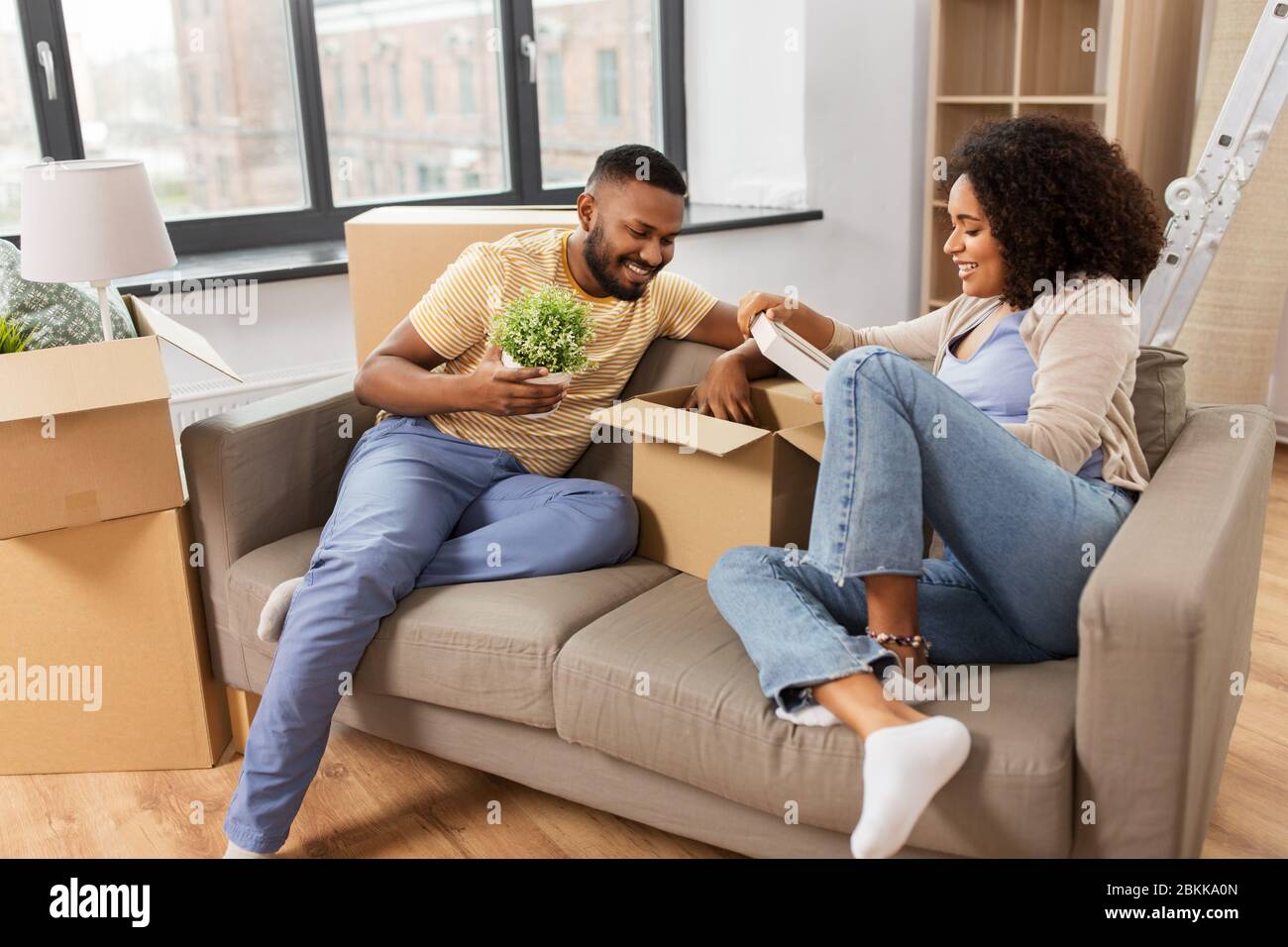 happy couple with boxes moving to new home Stock Photo - Alamy