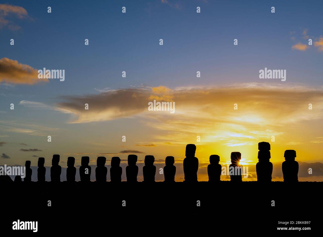 The fifteen Moai of Ahu Tongariki at Sunrise with a pretty sun star and the Pacific Ocean in the background, Rapa Nui (Easter Island), Chile. Stock Photo