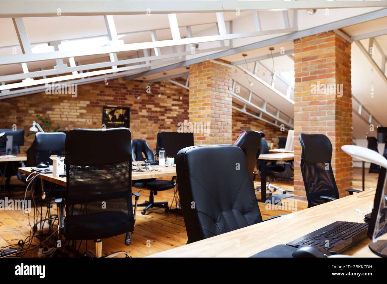 Many workplaces with computers, shelves and lockers Stock Photo