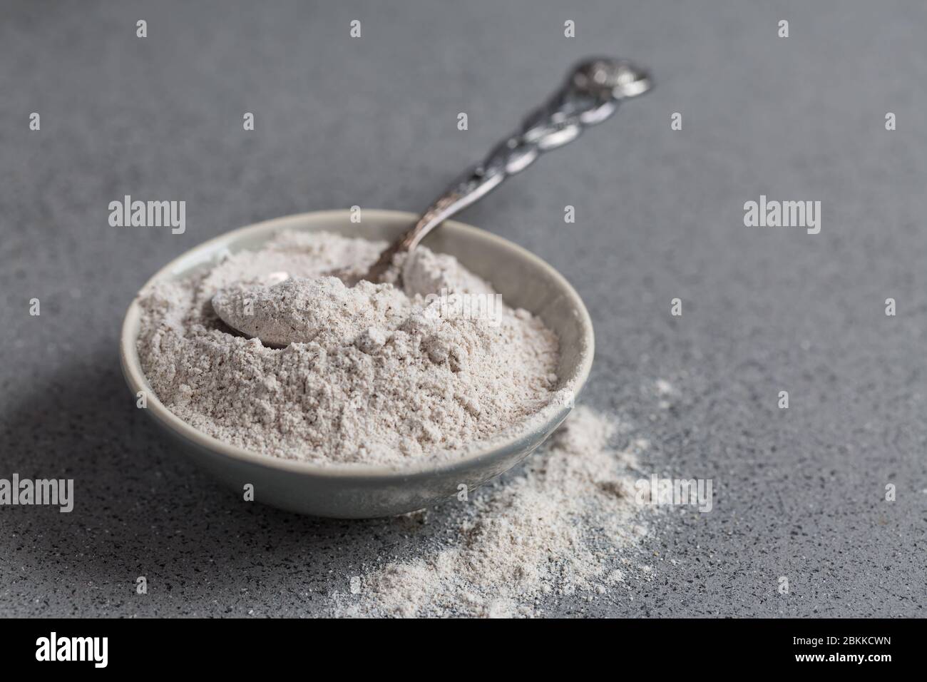 Glutenfree buckwheat flour for baking in the bowl on grey background Stock Photo