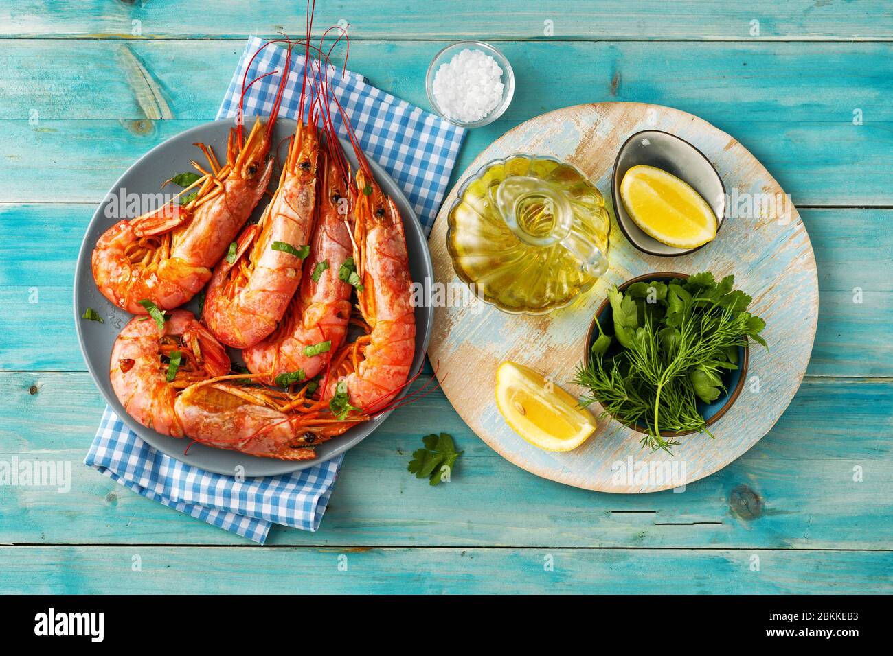 Top view of blue color dining table with cooked red prawns and ingredients Stock Photo