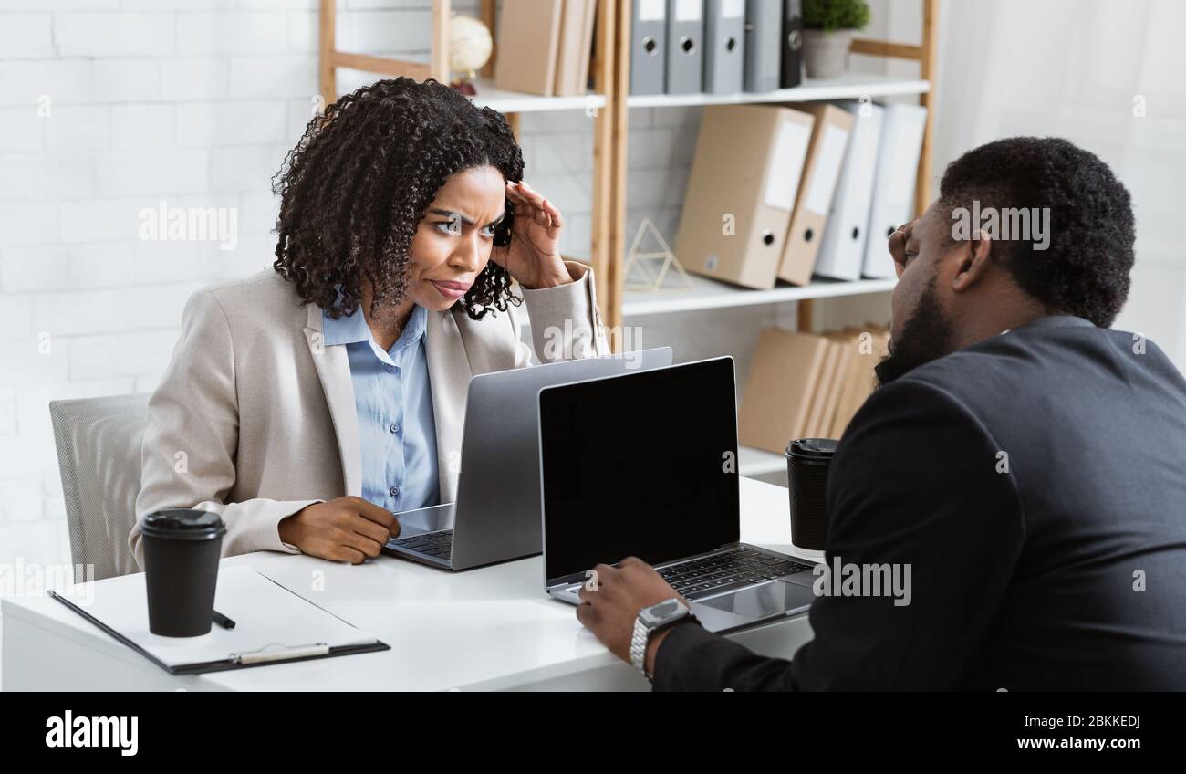 Millennial African American collagues having conflict in office, empty space. Panorama Stock Photo
