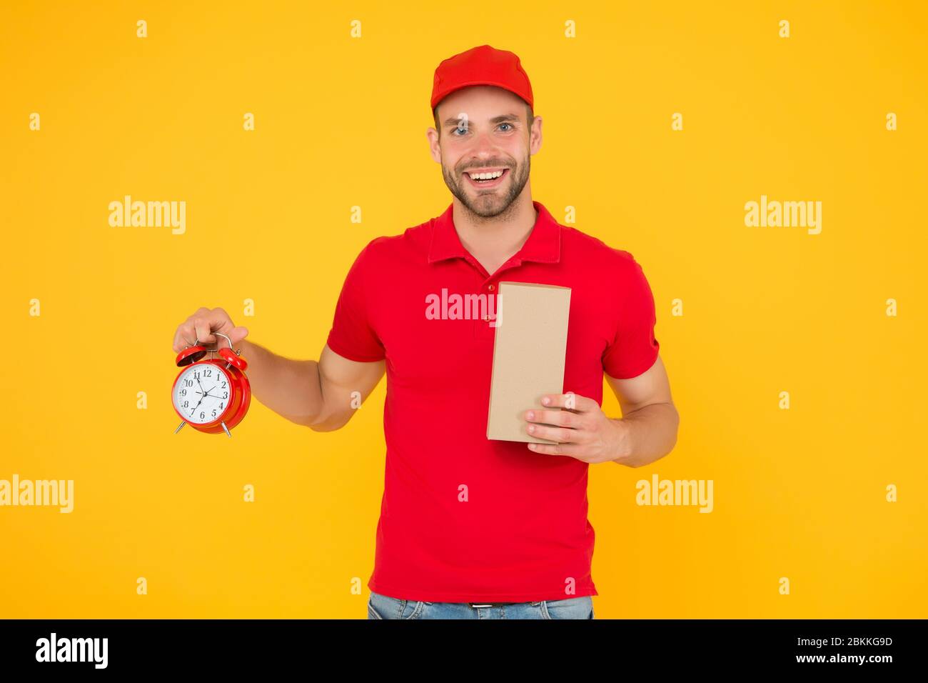 Real joy. go online shopping. Delivery during quarantine. friendly staff man. delivery time. Delivery Courier with time clock holding box. take your parcel. gift delivery man holding vintage clock. Stock Photo