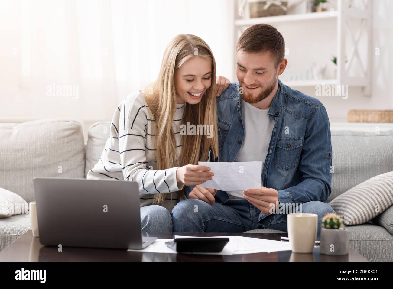 Happy married couple looking at personal finances at home Stock Photo