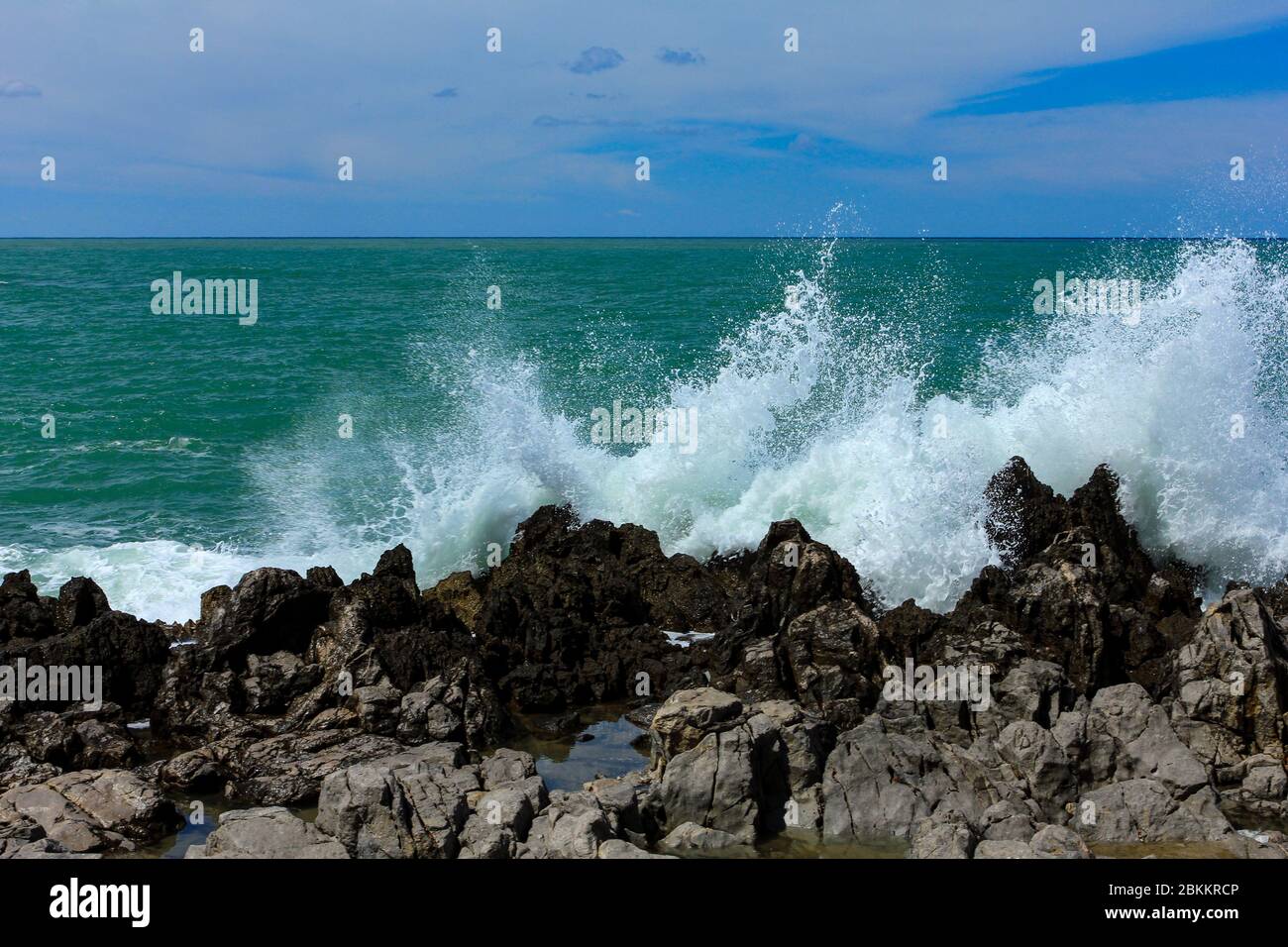 Sea waves crash and splash on rocks.  Stock Photo