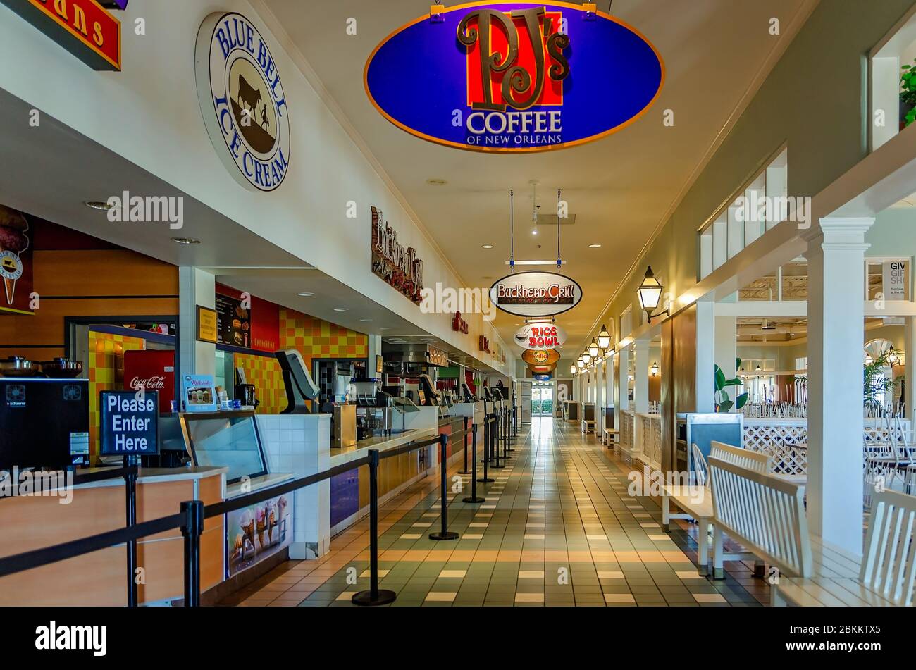 Chairs are stacked on tables, restaurants are dark, and the Food Court is closed due to COVID-19 at Gulfport Premium Outlets in Gulfport, Mississippi. Stock Photo