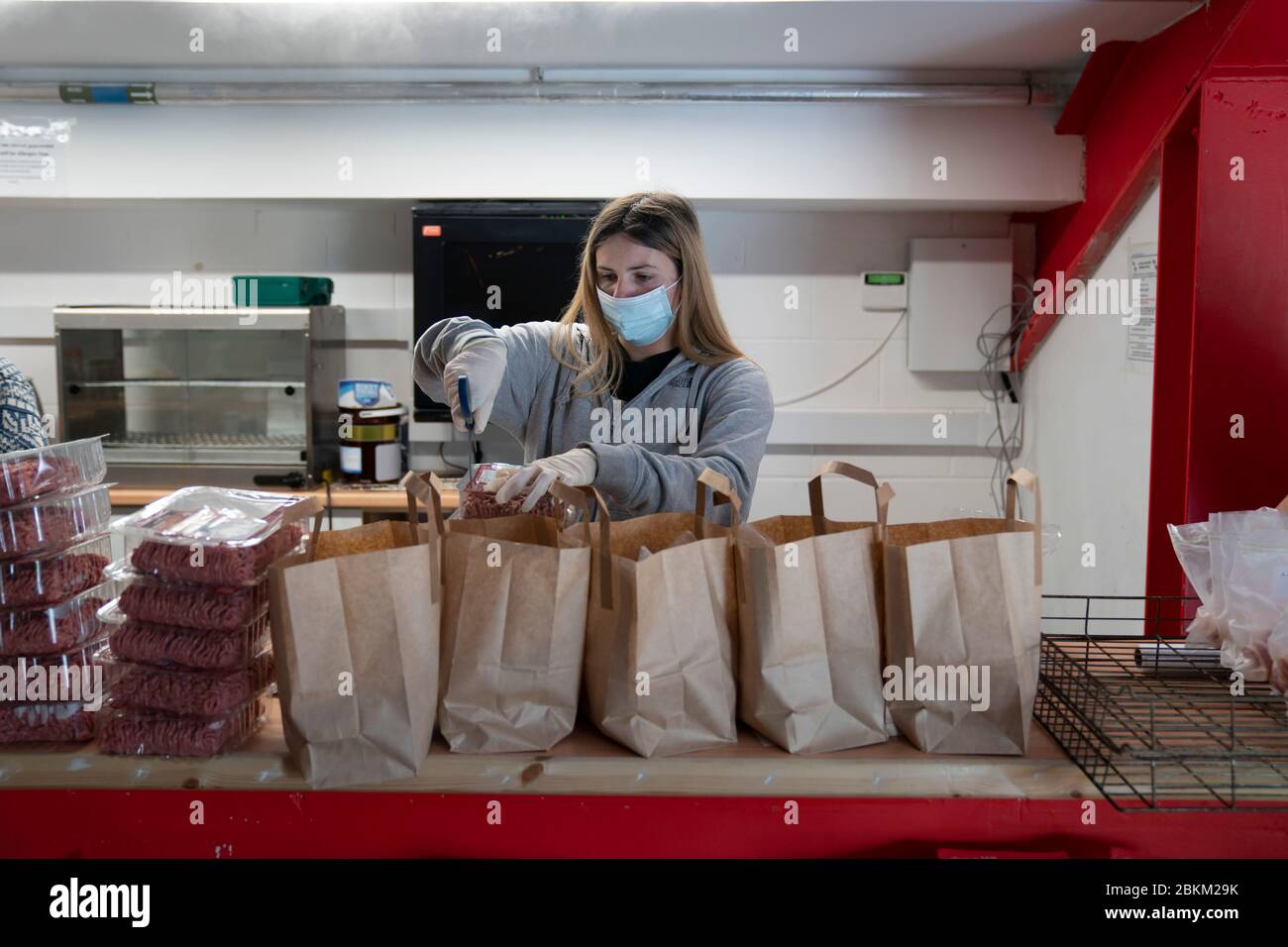 Manchester, Britain. 4th May, 2020. Volunteer and fan Hannah Gorman prepares food parcels as staff and supporters of Football Club United of Manchester help run a food distribution hub at the club's Broadhurst Park Stadium to prepare and deliver food to the most vulnerable in their community in Manchester, Britain, May 4, 2020. Credit: Jon Super/Xinhua/Alamy Live News Stock Photo