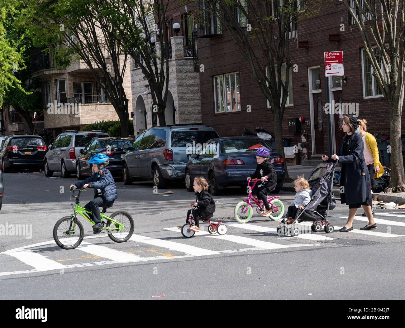 New York, NY - May 4, 2020: Young mother crossing intersection with ...