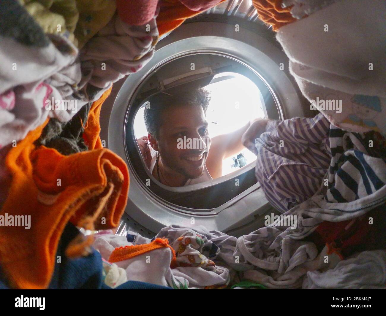 Bearded man using washing machine at home Stock Photo