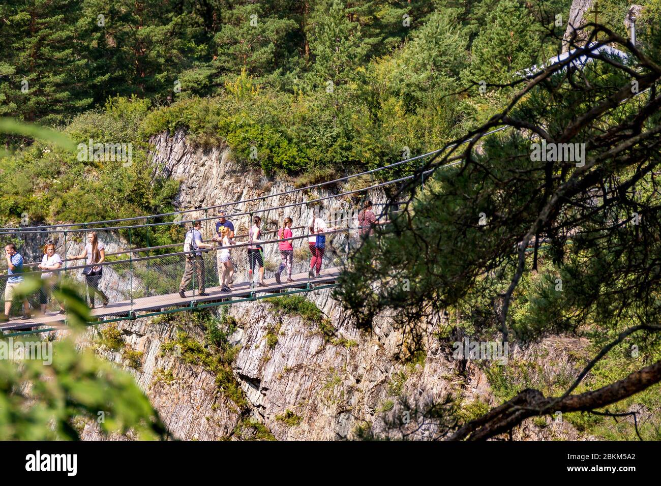 Altai Republic, Russia - 2019, people walk on a suspension bridge over a precipice, selective focus Stock Photo