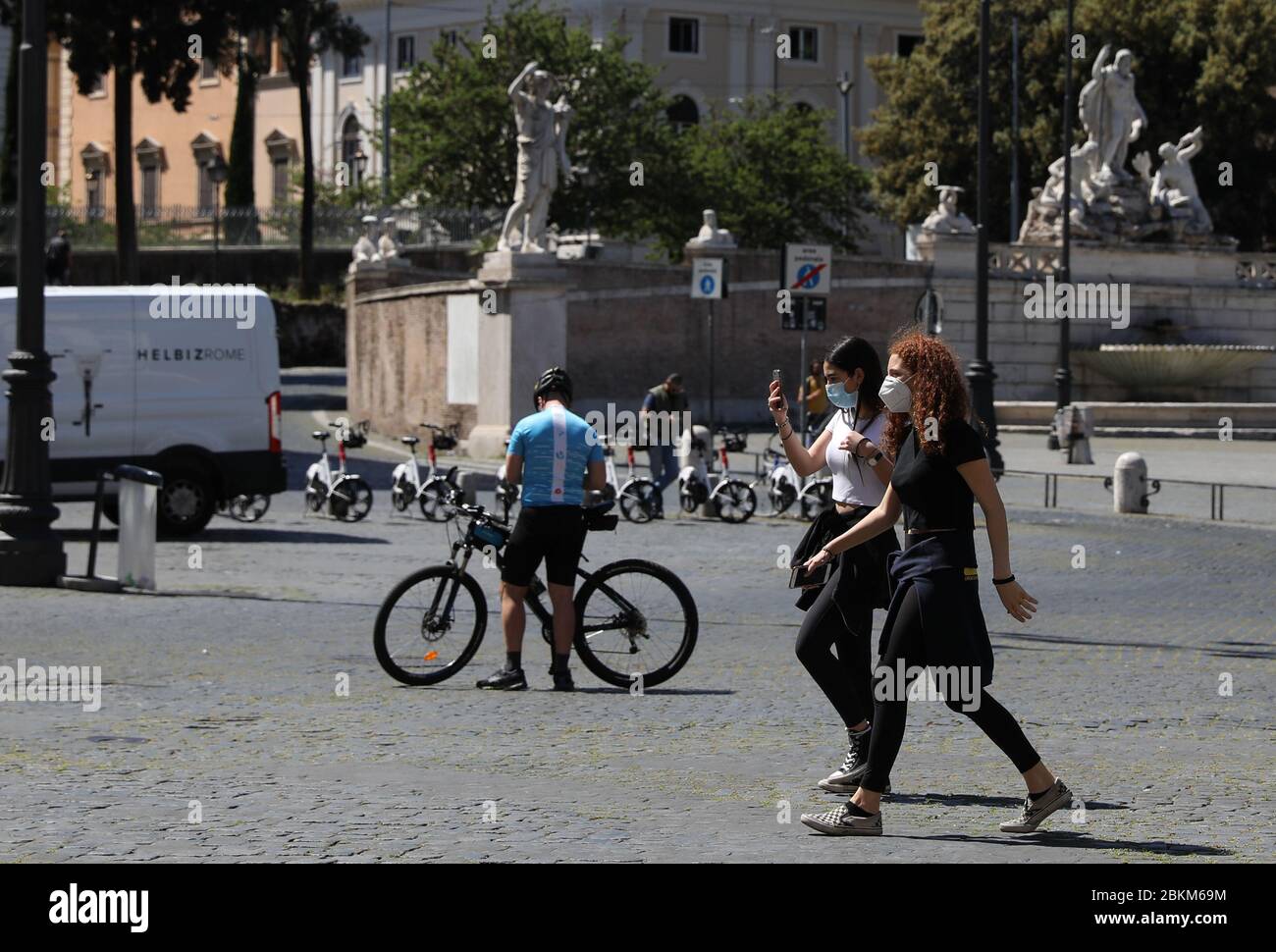 Rome, Italy. 4th May, 2020. Two women wearing face masks walk across the Piazza del Popolo in Rome, Italy, May 4, 2020. The coronavirus pandemic has claimed over 29,000 lives in Italy, bringing the total number of infections, fatalities and recoveries to 211,938 as of Monday, according to the latest data released by the country's Civil Protection Department. Italians enjoyed more liberties on Monday, as some restrictions on productive activities and personal movements were relaxed for the first time after almost eight weeks. Credit: Cheng Tingting/Xinhua/Alamy Live News Stock Photo