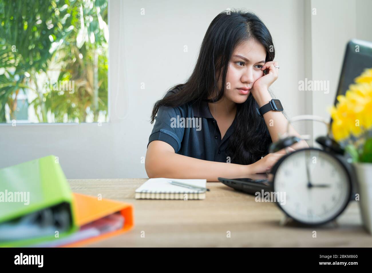 Work from home during the outbreak of the virus. Asian Women Work from home, use a laptop to work. Online Meetings Video Conferrence with the team in Stock Photo