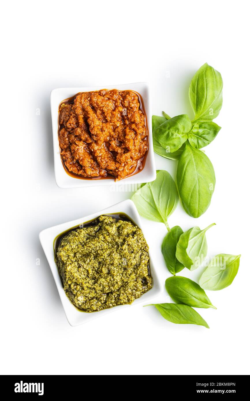 Green basil and red tomato pesto dip sauce and basil leaves isolated on