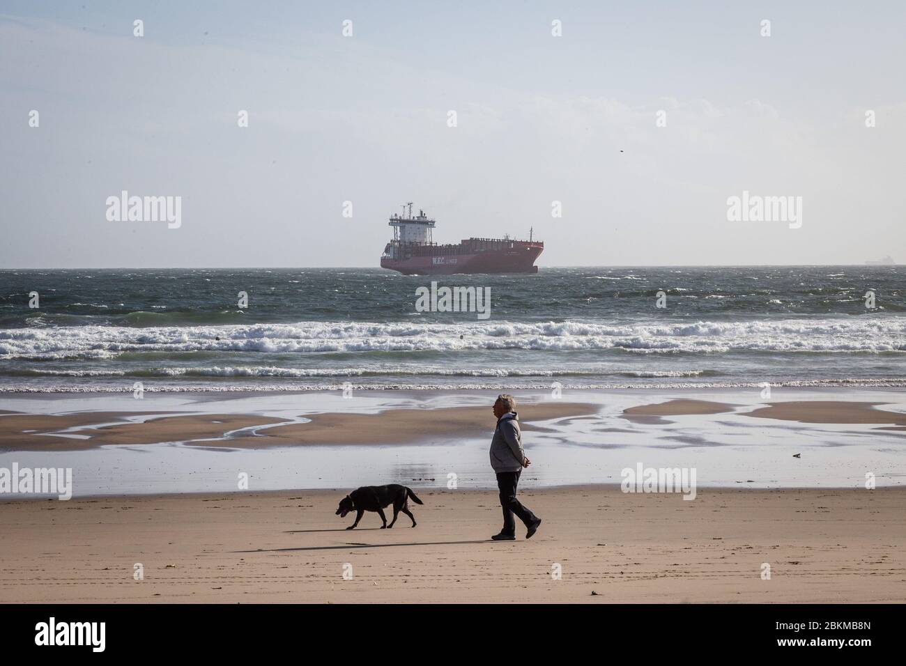 Matosinhos, Portugal. 04th May, 2020. A man walks with his dog along the Matosinhos beach. The state of calamity was declared in the country and people practising water sports were allowed to access the beaches with strict coronavirus preventive measures put across. Credit: SOPA Images Limited/Alamy Live News Stock Photo